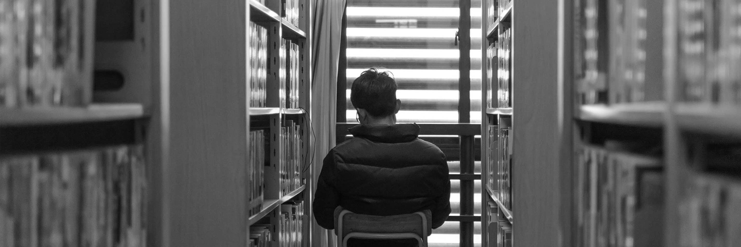 student sitting in a library row
