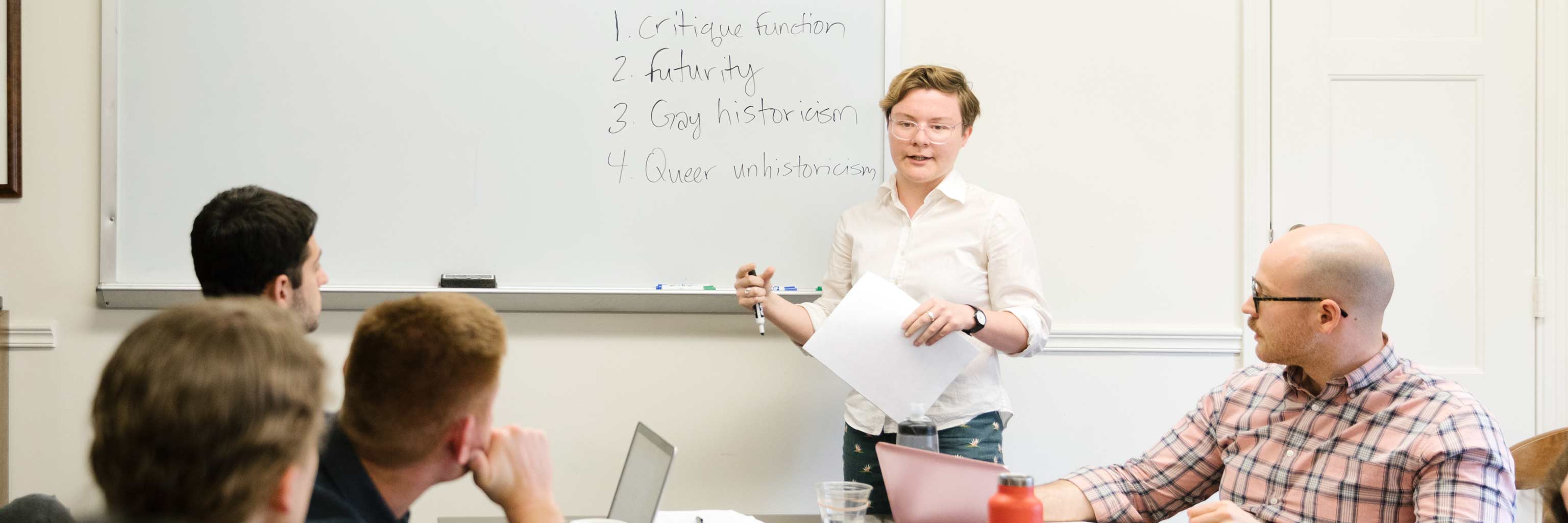 woman presenting to other people at desks