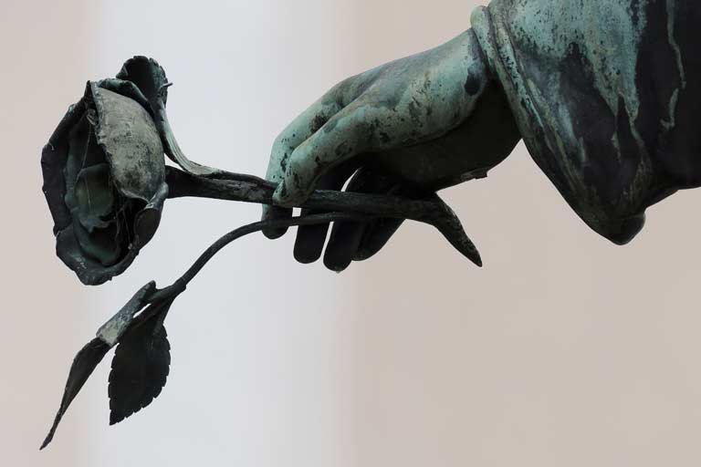 Statue of a hand holding a rose